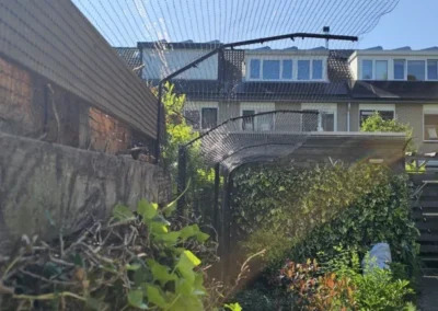 Katvriendelijke tuin in Amstelveen met veilige omheining, veel groen, loungeplekjes en speelplekjes voor katten.