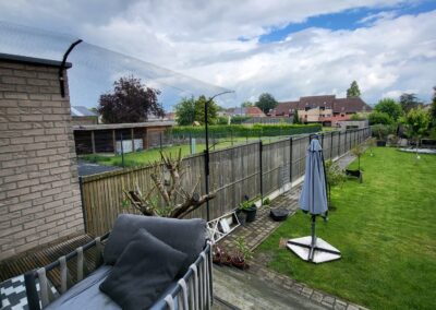 Katvriendelijke tuin in Oudenaarde, België met veilige omheining, veel groen, loungeplekjes en klimopties voor katten.