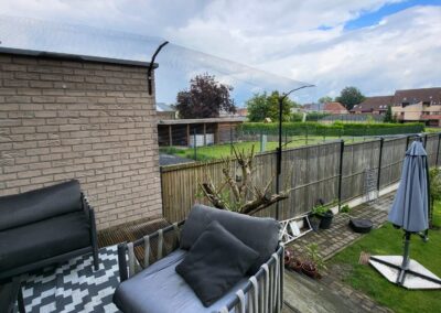 Katvriendelijke tuin in Oudenaarde, België met veilige omheining, veel groen, loungeplekjes en klimopties voor katten.